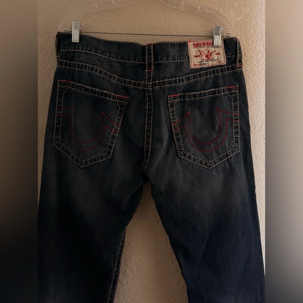 True Religion jeans feature a dark wash and bold signature stitching. Skinny